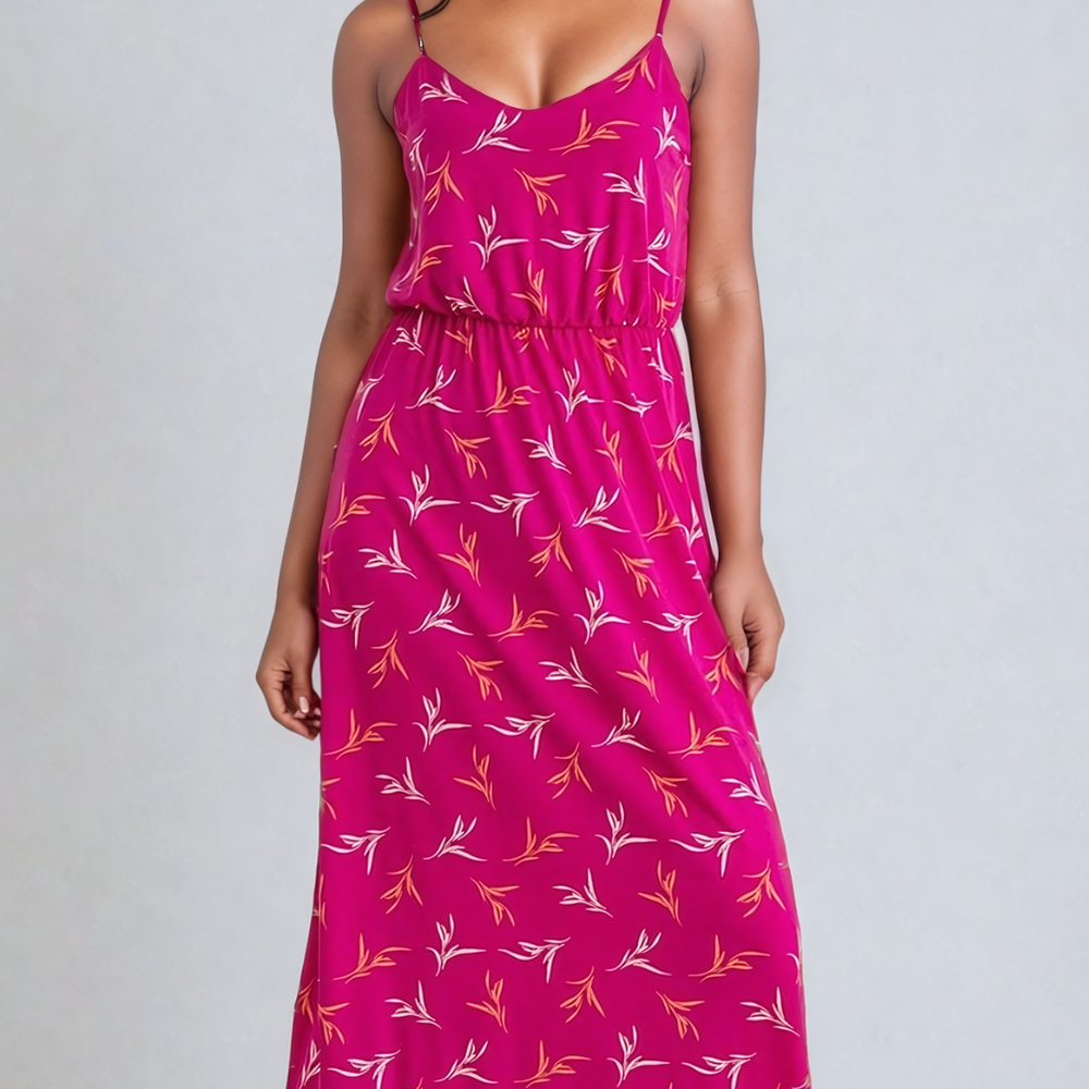 Image of a woman wearing a Fly Away Cami Maxi Dress in a vibrant floral print, suitable for various occasions, with adjustable straps and a flattering cami neckline.
